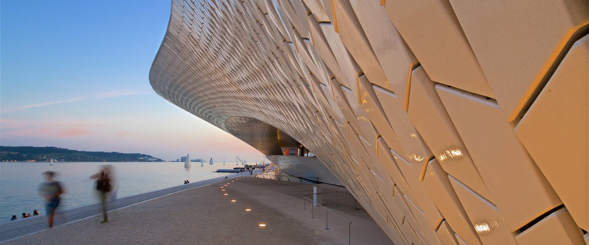 Lisboa Distrito que incluye una puesta de sol, una bahía o puerto y arquitectura moderna