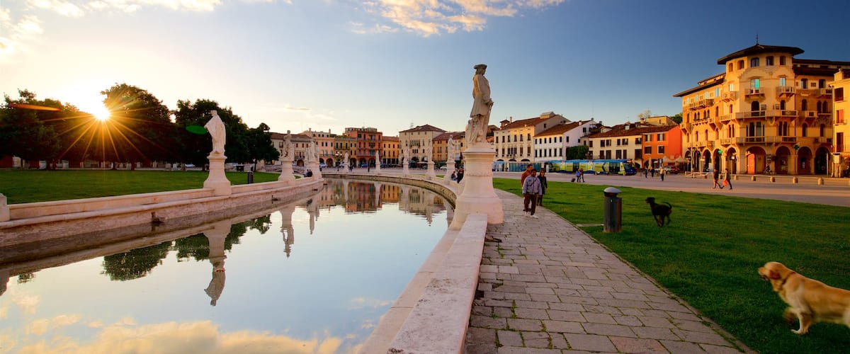 Prato della Valle joka esittää joki tai puro, patsas tai veistos ja auringonlasku