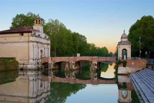 Porta Ognissanti mettant en vedette pont, riviĂšre ou ruisseau et coucher de soleil
