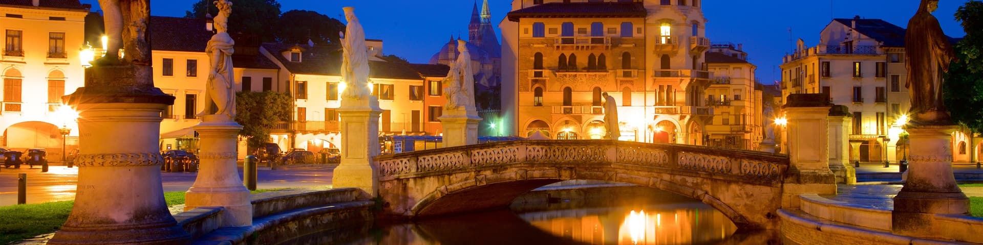 Prato della Valle featuring a statue or sculpture, night scenes and a river or creek
