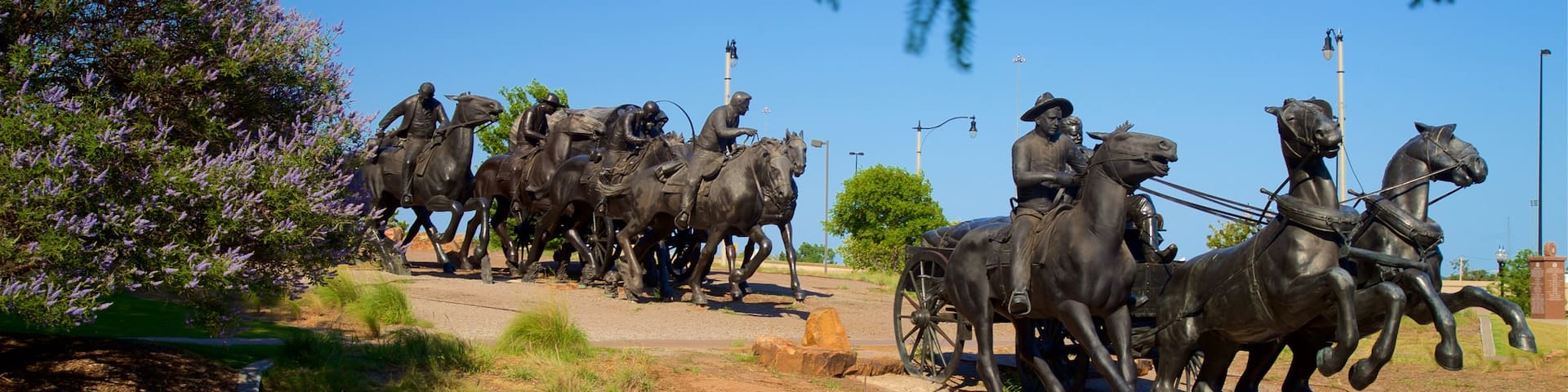 Centennial Land Run Monument featuring a pond and a statue or sculpture