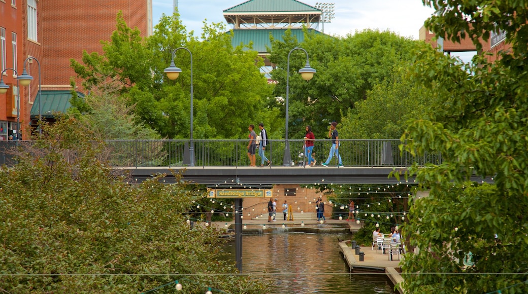 Bricktown featuring a river or creek and a bridge as well as a small group of people