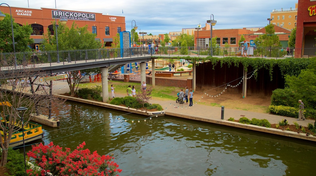 Bricktown som viser blomster, en bro og en flod eller et vandløb