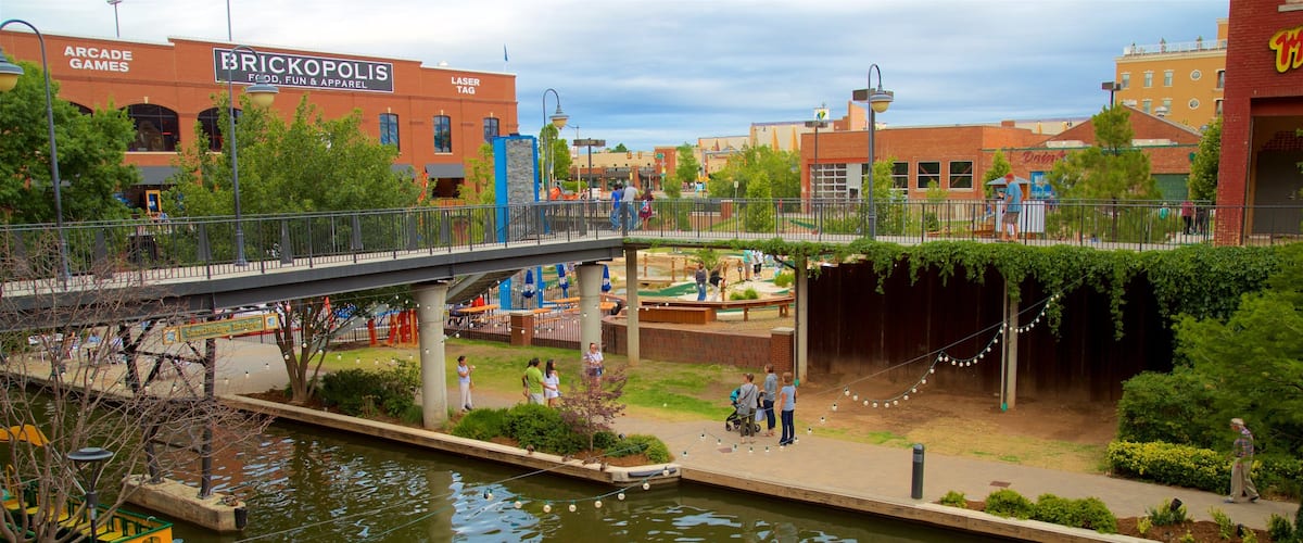 Bricktown which includes flowers, a bridge and a river or creek