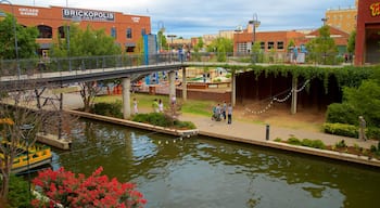 Bricktown which includes flowers, a bridge and a river or creek