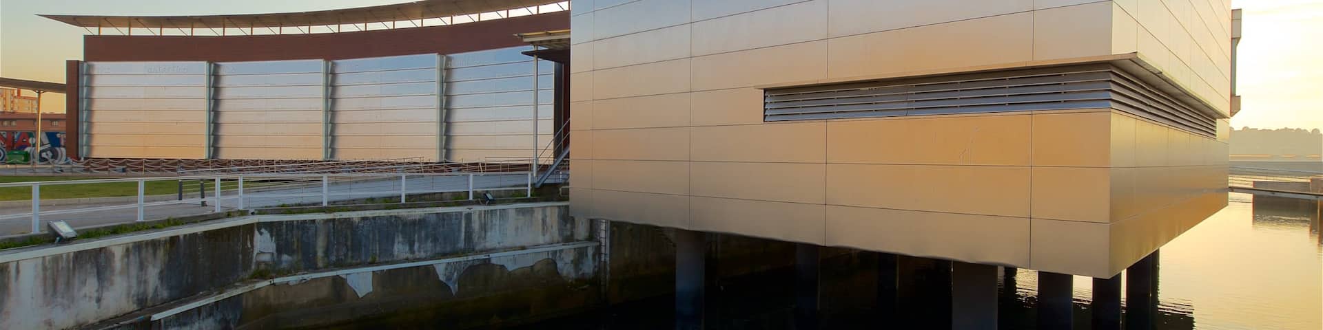 Aquarium de GijĂłn mettant en vedette coucher de soleil, signalisation et architecture moderne