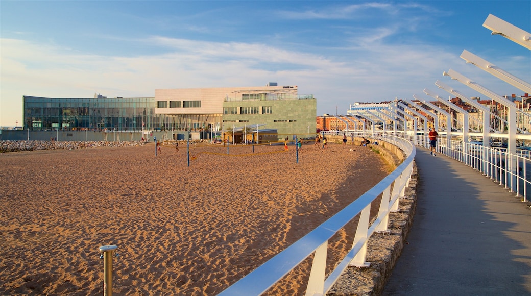 Talasoponiente featuring a sandy beach, a coastal town and a sunset