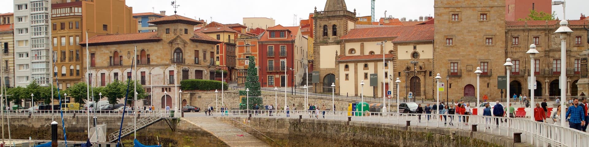 Palacio de Revillagigedo which includes a city and a bay or harbor as well as a large group of people