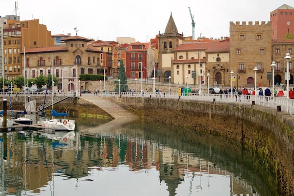 Palacio de Revillagigedo featuring a bay or harbour and a city as well as a large group of people