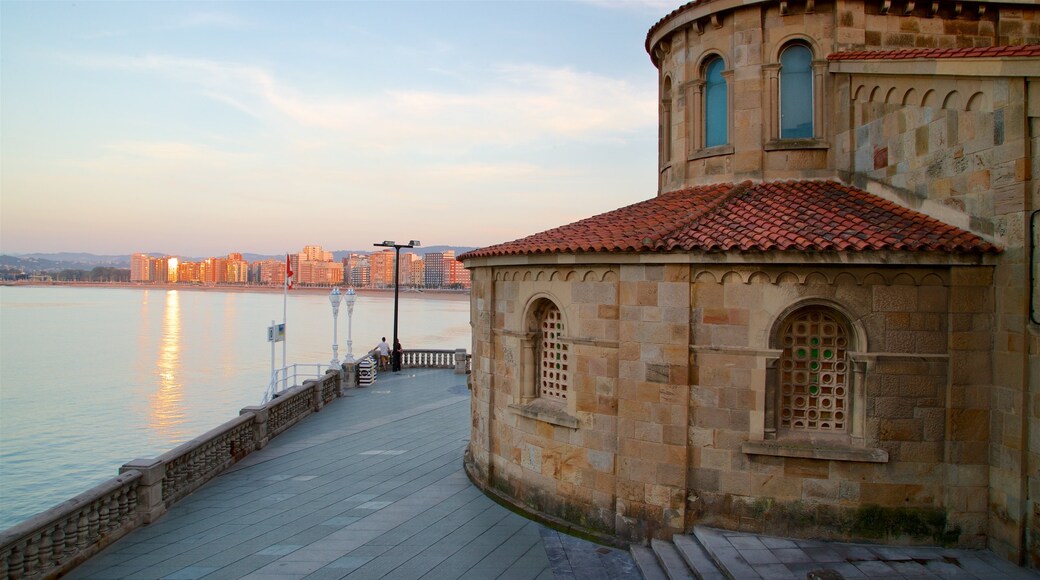 Gijon showing a city, a sunset and heritage elements