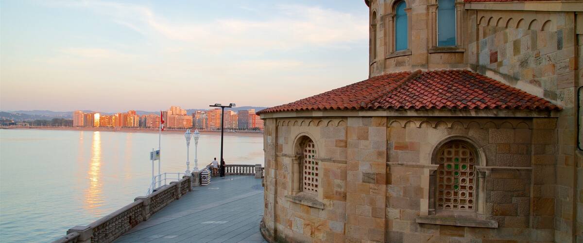 Gijón mostrando una puesta de sol, una ciudad costera y una ciudad
