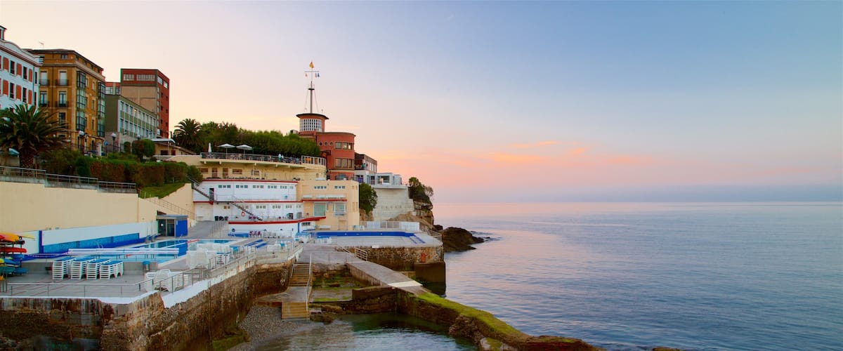 Gijón ofreciendo una ciudad costera, una puesta de sol y vistas generales de la costa