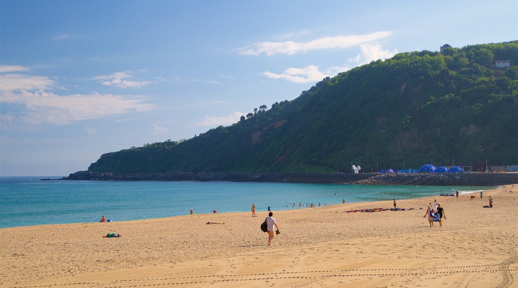 Playa de Zurriola ofreciendo vistas de una costa y una playa y también un grupo pequeño de personas