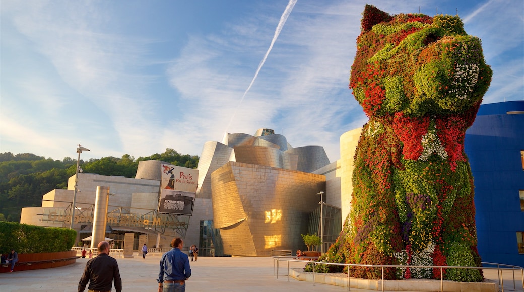 Guggenheim Museum Bilbao which includes modern architecture, outdoor art and a sunset