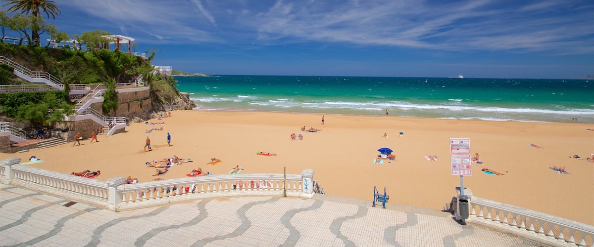 Jardines de Piquio showing a beach and general coastal views as well as a small group of people