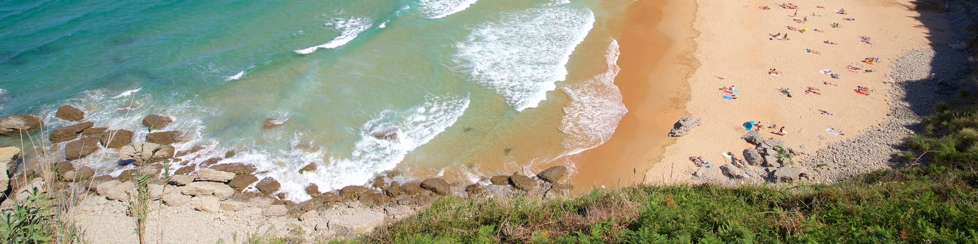 Santander showing rugged coastline, a sandy beach and general coastal views