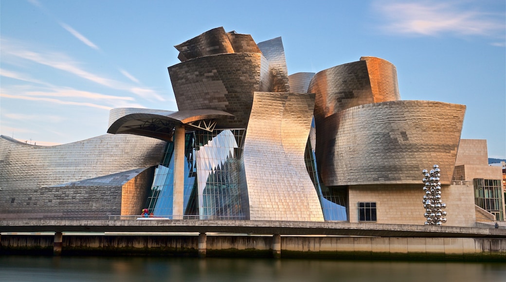 Guggenheim Museum Bilbao showing modern architecture, a river or creek and a sunset