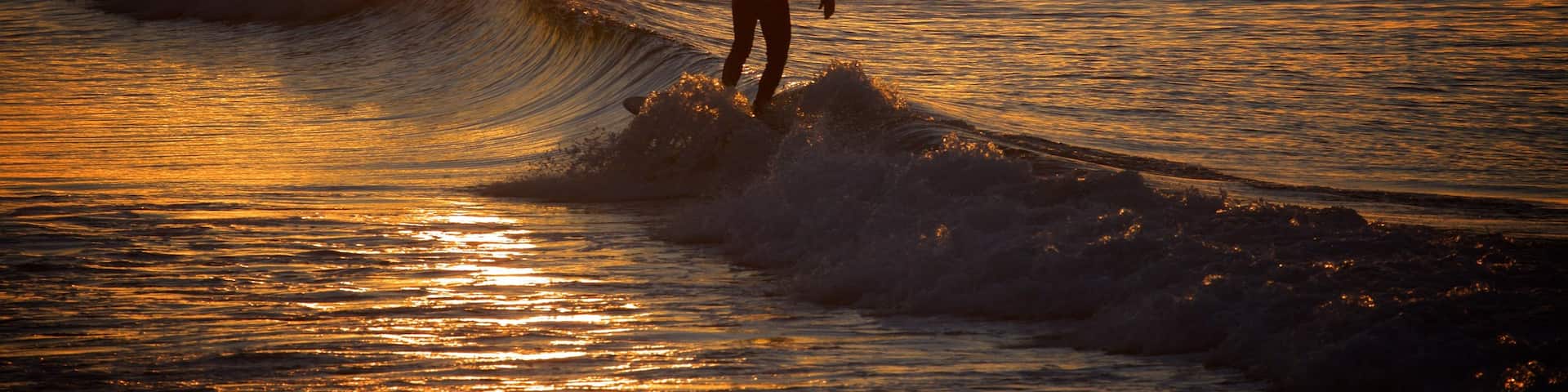 Coolangatta Beach which includes a sunset, surf and general coastal views