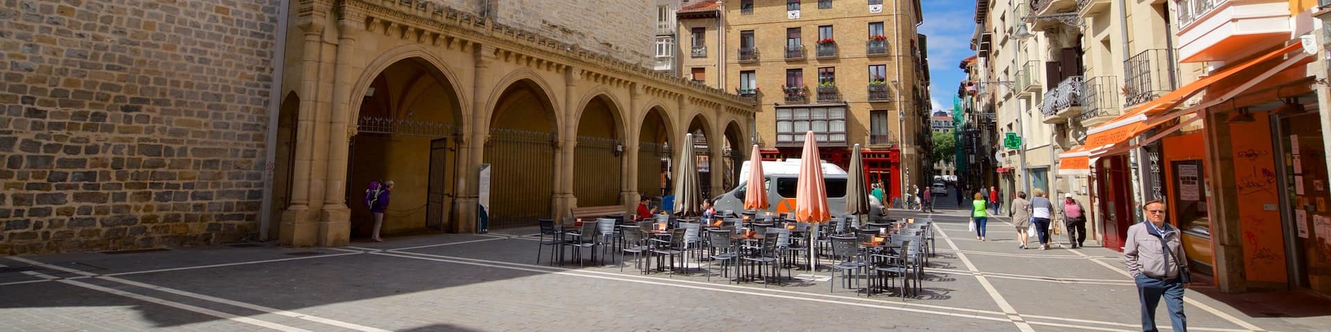 Iglesia de San Nicolas which includes a city and street scenes as well as a small group of people