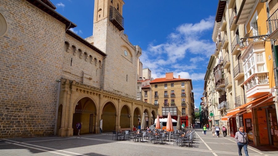 Iglesia de San Nicolas which includes a city and street scenes as well as a small group of people