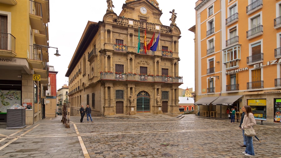 Rathaus von Pamplona das einen historische Architektur und Straßenszenen sowie Paar