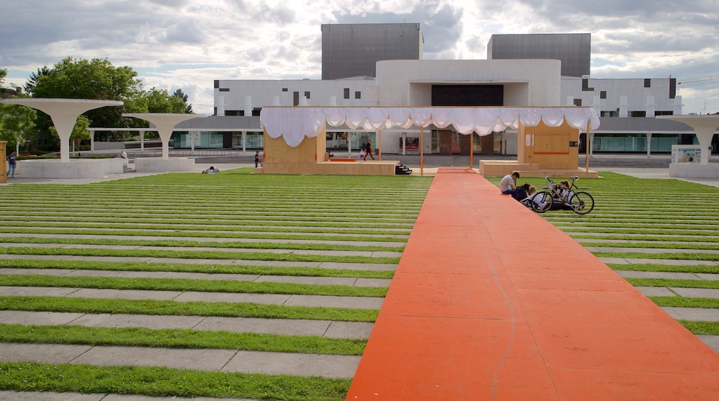 Teatro Estatal de Darmstadt ofreciendo arquitectura moderna y un jardín y también un pequeño grupo de personas