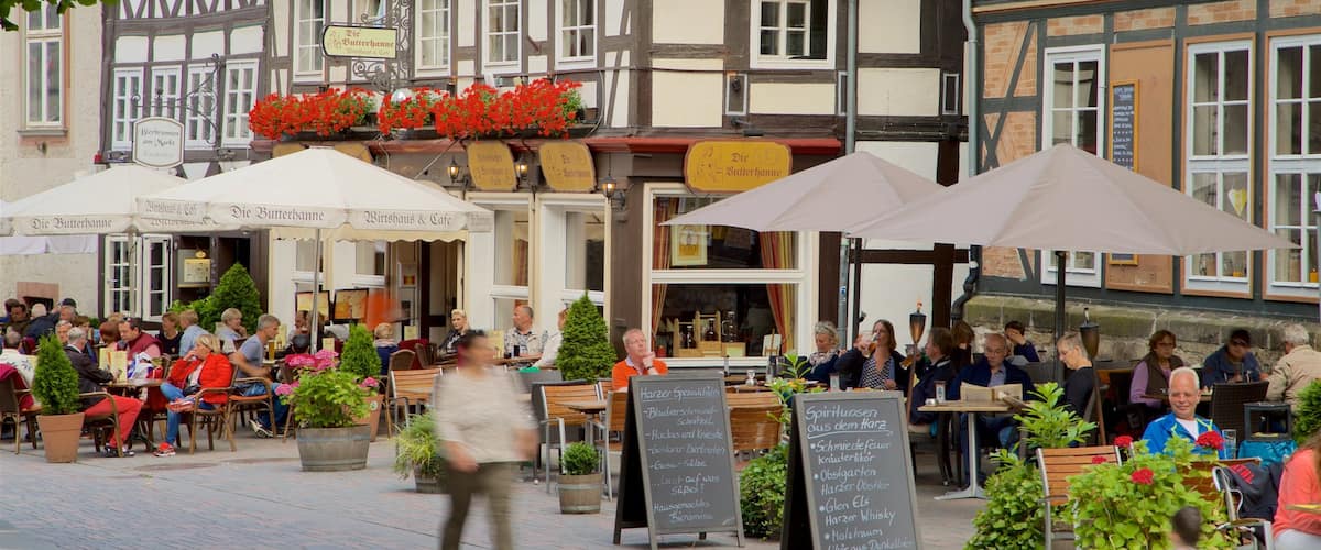 Casco antiguo de Goslar mostrando señalización y comer al aire libre y también un pequeño grupo de personas