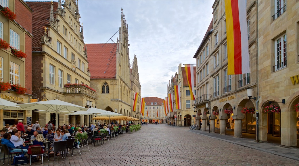 Münster/Munster mostrando comer al aire libre y elementos del patrimonio y también un pequeño grupo de personas