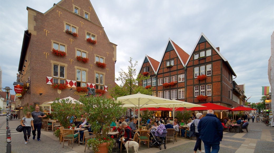 Münster/Munster mostrando comer al aire libre y elementos del patrimonio y también un pequeño grupo de personas