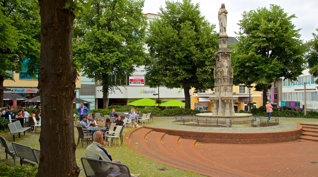 Marienplatz Paderborn caracterizando uma estĂĄtua ou escultura e uma fonte assim como um pequeno grupo de pessoas