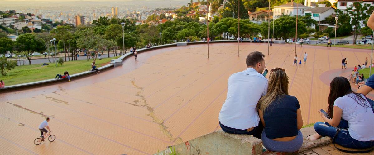Praça do Papa que inclui um pôr do sol e uma praça ou plaza assim como um pequeno grupo de pessoas