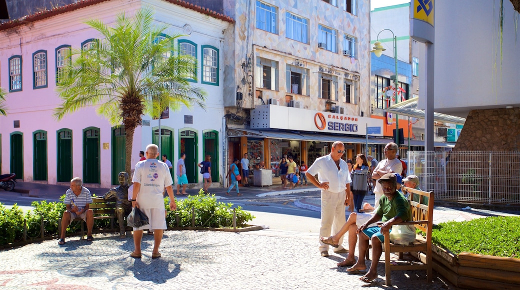 Praça Nilo Peçanha que inclui um jardim assim como um pequeno grupo de pessoas