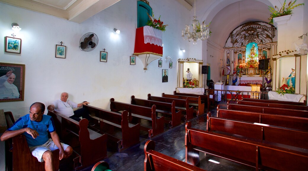 Santa Luzia Church featuring a church or cathedral and interior views as well as a small group of people