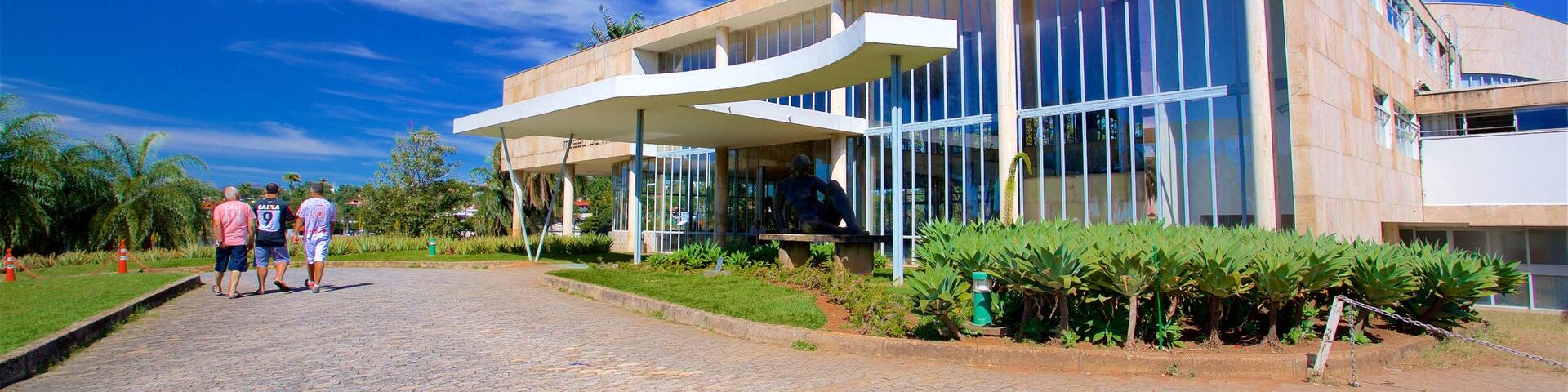 Pampulha Art Museum featuring a park and modern architecture as well as a small group of people