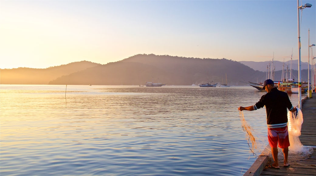 Paraty Wharf which includes a bay or harbour, fishing and a sunset