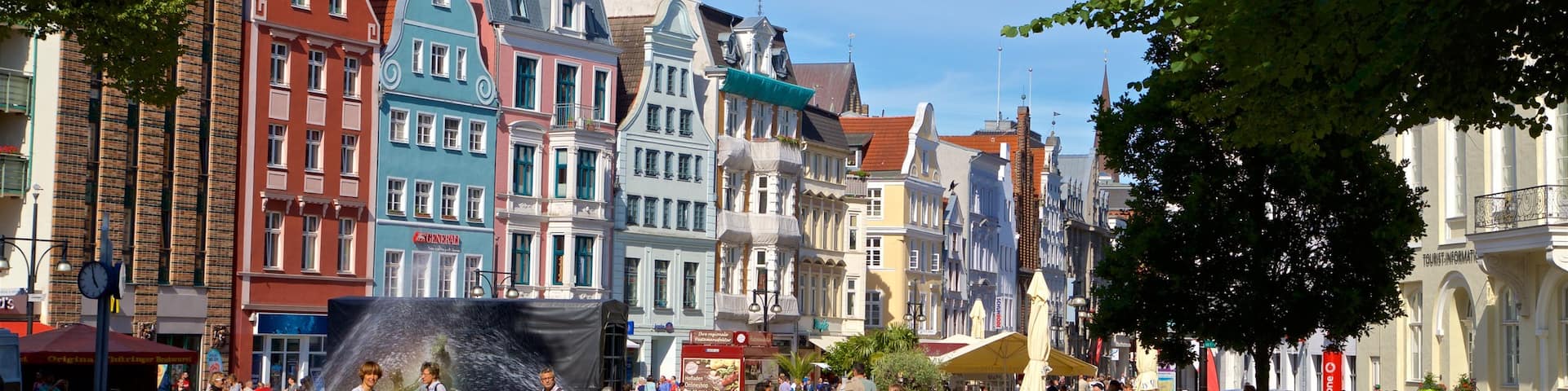 Rostock das einen Garten und Stadt sowie kleine Menschengruppe