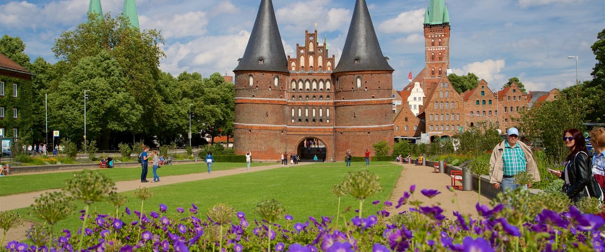 Museum Holstentor featuring heritage architecture and wildflowers as well as a small group of people