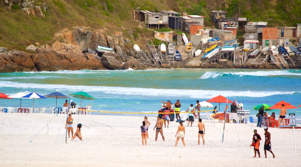 Arraial do Cabo che include spiaggia sabbiosa e vista della costa cosi come un piccolo gruppo di persone