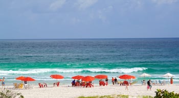 Arraial do Cabo caratteristiche di spiaggia sabbiosa e vista della costa cosi come un piccolo gruppo di persone