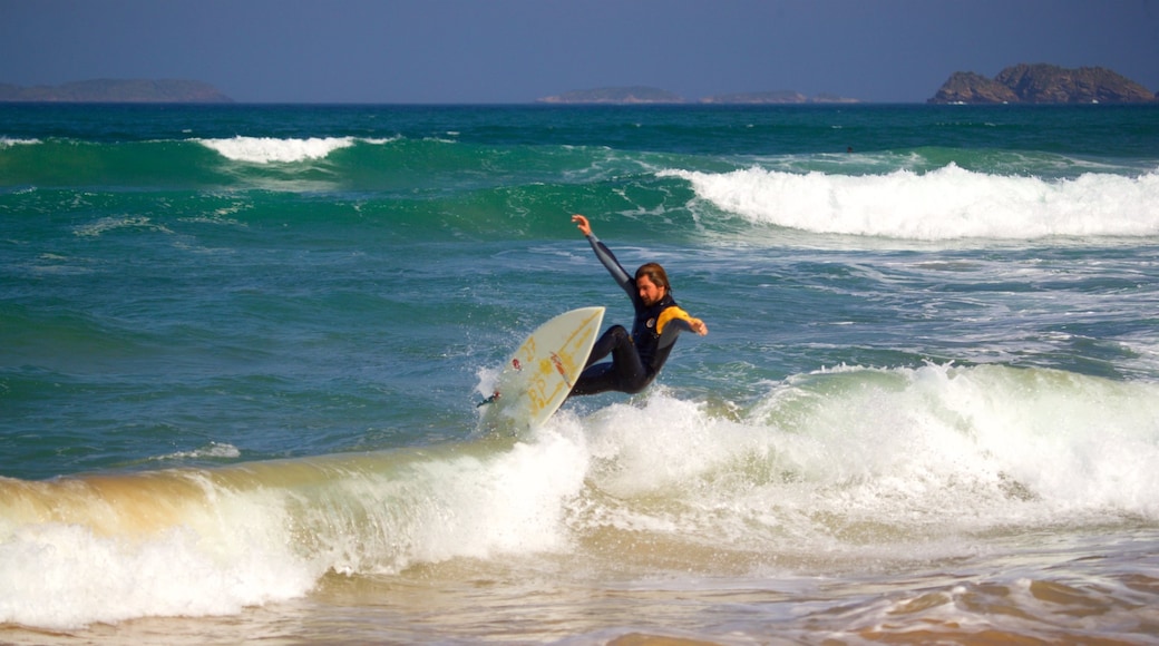 Playa Geriba que incluye surf y vistas generales de la costa y también un hombre