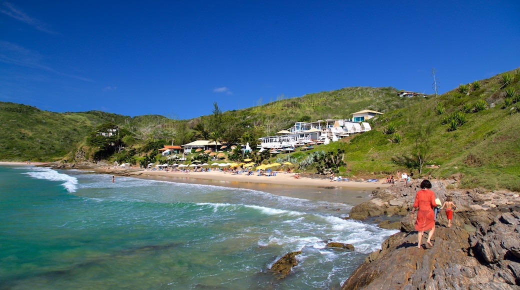 Playa Brava ofreciendo una ciudad costera y vistas generales de la costa y también una familia