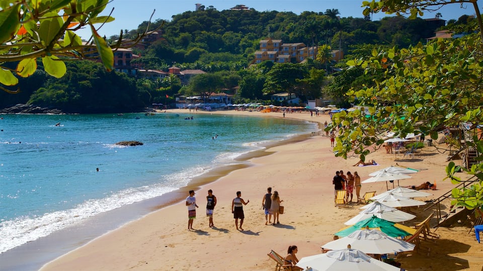 Praia João Fernandes inclusief algemene kustgezichten en een zandstrand en ook een klein groepje mensen