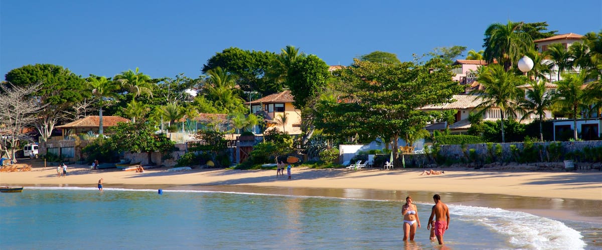Praia da Ferradura caracterizando natação, uma cidade litorânea e uma praia de areia
