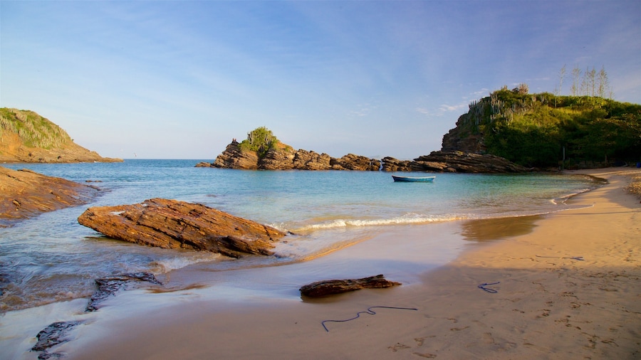 Playa Ferradurinha que incluye costa escarpada, vistas generales de la costa y una puesta de sol