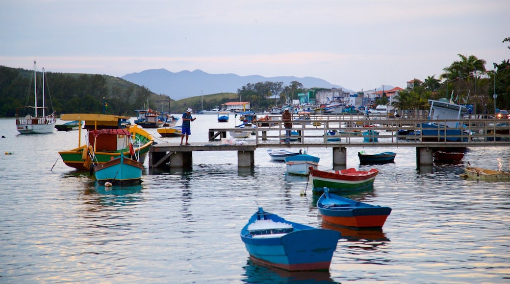 Cabo Frio mostrando uma cidade litorânea e uma baía ou porto assim como um homem sozinho