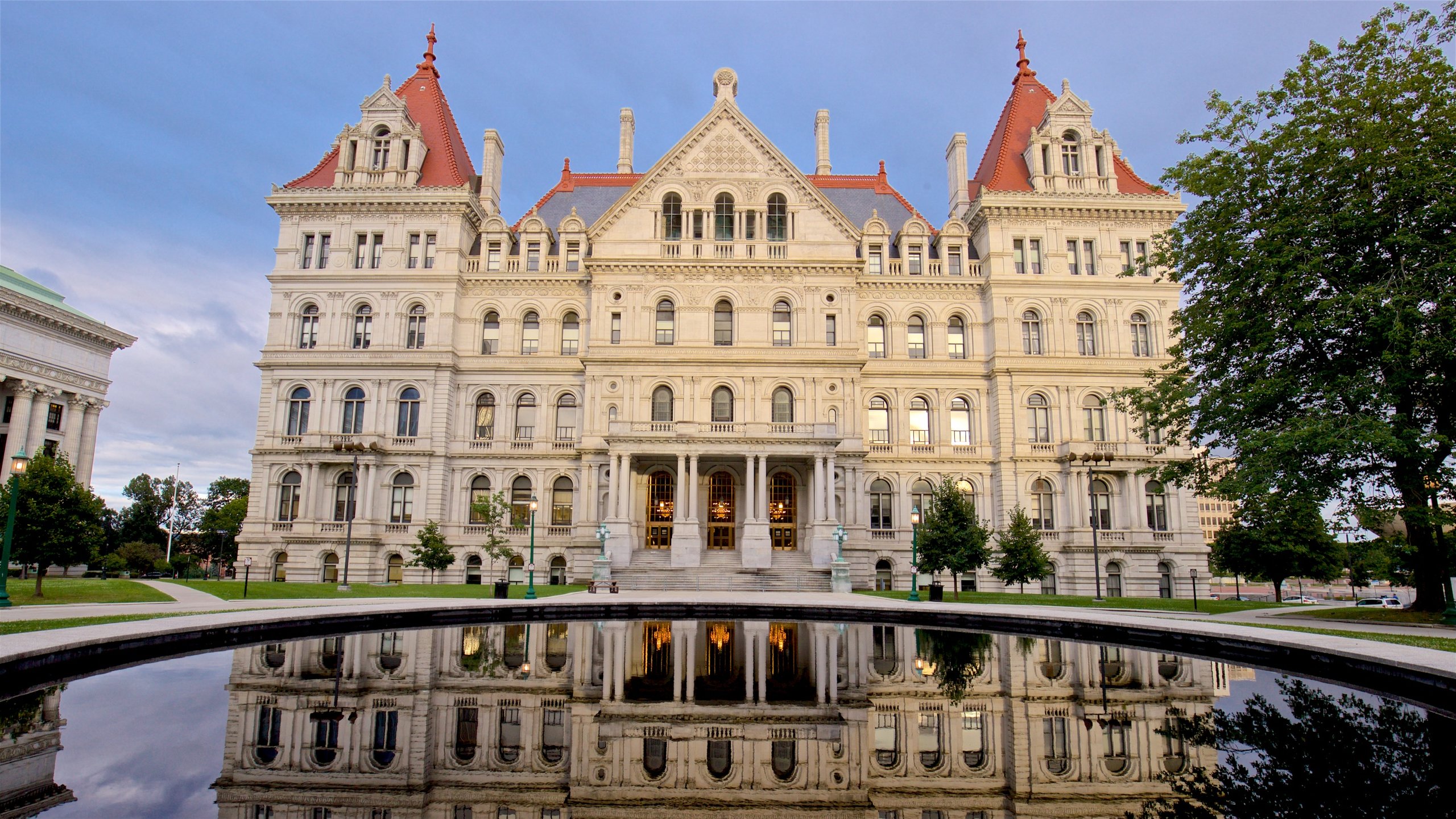 New York State Capitol Building featuring heritage architecture and a pond