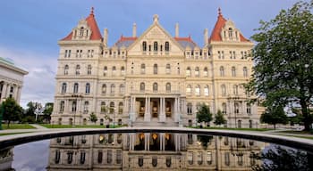 New York State Capitol Building featuring heritage architecture and a pond