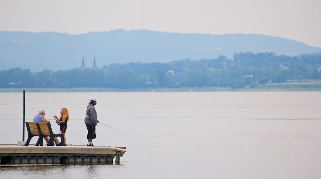 Onondaga Lake Park ofreciendo pesca y un lago o espejo de agua y también un pequeño grupo de personas