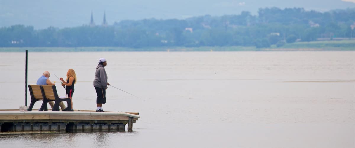 Onondaga Lake Park ofreciendo pesca y un lago o abrevadero y también un pequeño grupo de personas