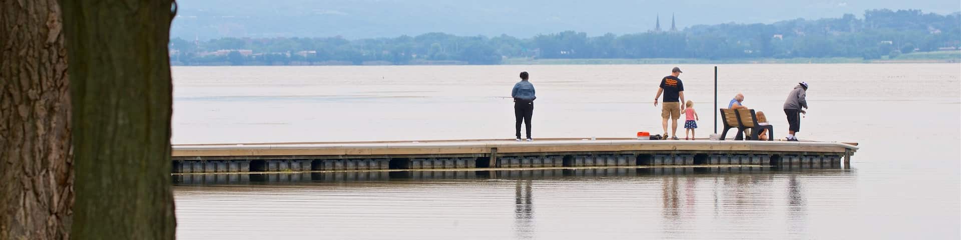 Onondaga Lake Park showing a lake or waterhole as well as a small group of people